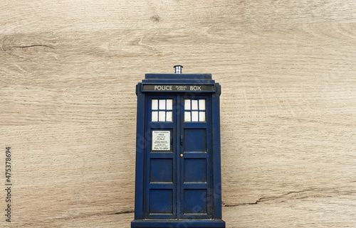 Police call box isolated on wooden background. Tardis from Doctor Who. Top view with copy space for your text. photo