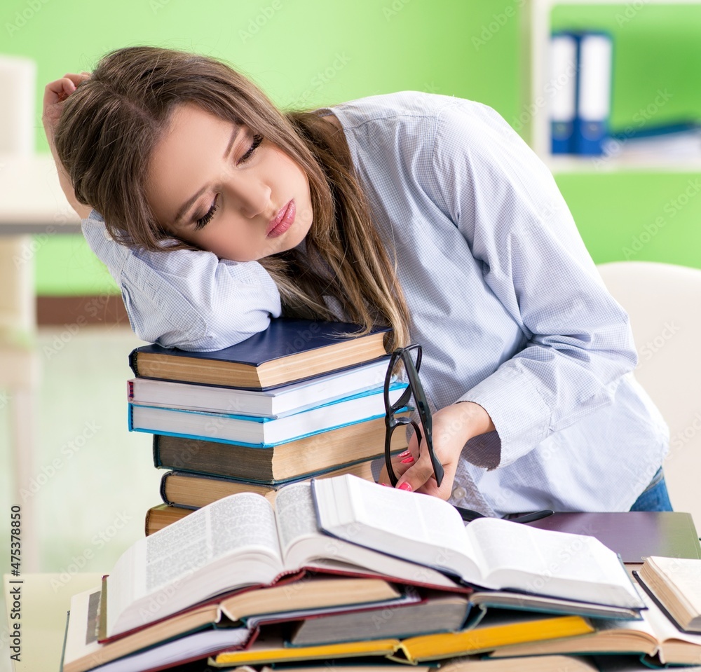 Young female student preparing for exams with many books Young female student preparing for exams with many books