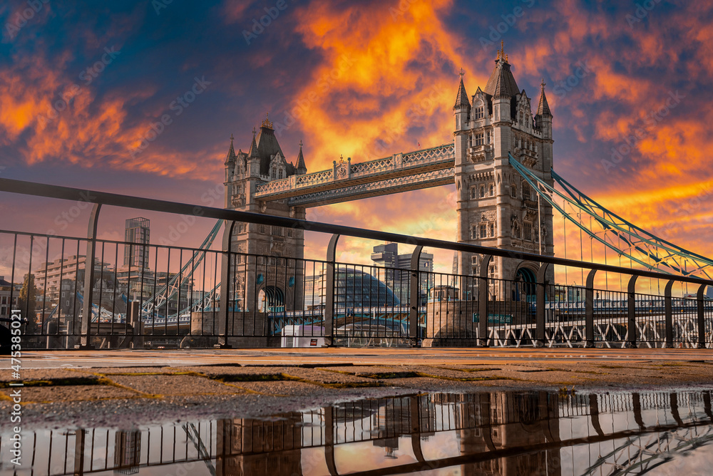 Fototapeta premium Iconic Tower Bridge view connecting London with Southwark over Thames River, UK. Beautiful view of the bridge during magical orange sunset over the city.