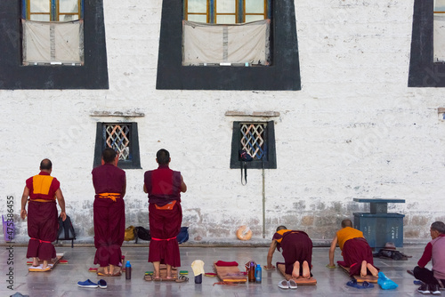 Fotografi Monks prostrate themselves praying before Jokhang Temple, part of the 'Historic