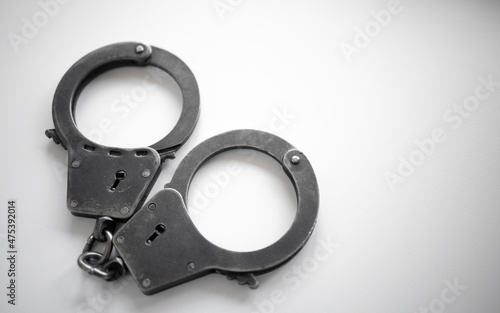 Metal handcuffs of a policeman on a white isolate. A clean place for text. Arrest of the suspect. criminal news.