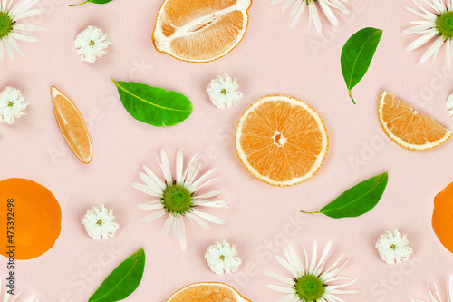 Seamless pattern of sliced lemon with fresh chamomile flowers on pink background. Top view, flat lay, design element. Creative summer minimalistic background.