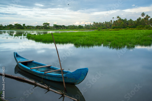 Blue color Wooden boat - Backwaters photography, typical landscape with palm trees and old hut, Kerala Backwaters, Kerala backwaters photography during day time Kadamakkudy Kerala photo