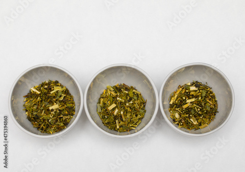 Three cups with tea leaves on white table