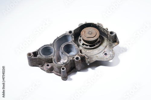 The pump is automobile on a white background. The water pump is dirty. Engine cooling system, bottom view.