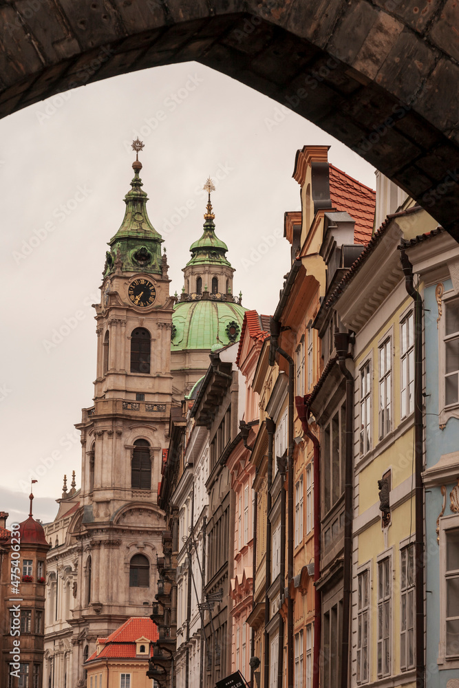 Prague, Czech Republic. View of church and other buildings from under an arch.