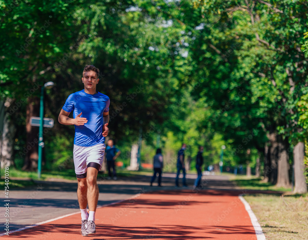 Handsome man jogging during sunny morning out on the race track