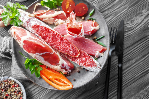 Italian meat dish. Dried meat and sausages on the kitchen board. Close-up of sliced salami sausage