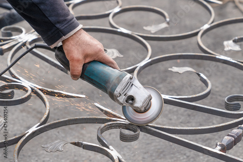 Metal grinding with angle grinder. Male hand and instrument. Working with metal.