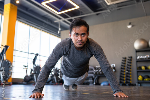 Portrait of a fitness person doing push ups in gym