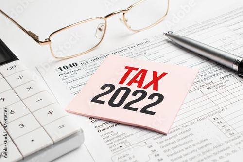 Tax forms with pen, calculator, glass and sticker. Tax 2022