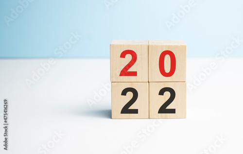woodblocks cubes with a number 2021 change to 2022 blue background. new year 2021- 2022 concept.