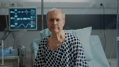 Φωτογραφία Portrait of elder patient with nasal oxygen tube standing on bed in hospital ward at medical clinic
