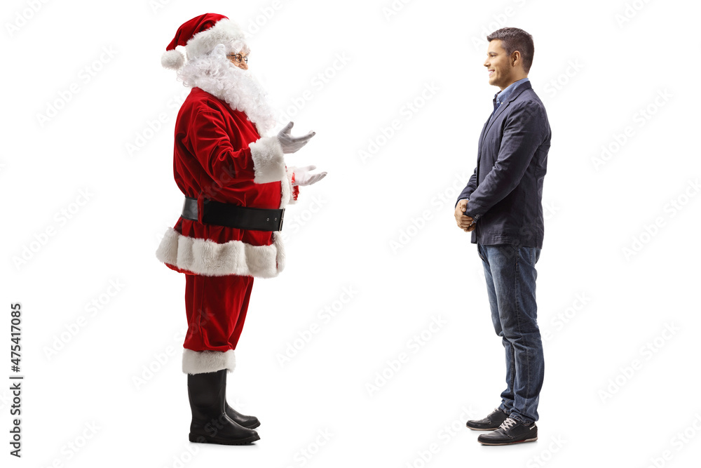 Full length profile shot of santa claus talking to a young man Full length profile shot of santa claus talking to a young man