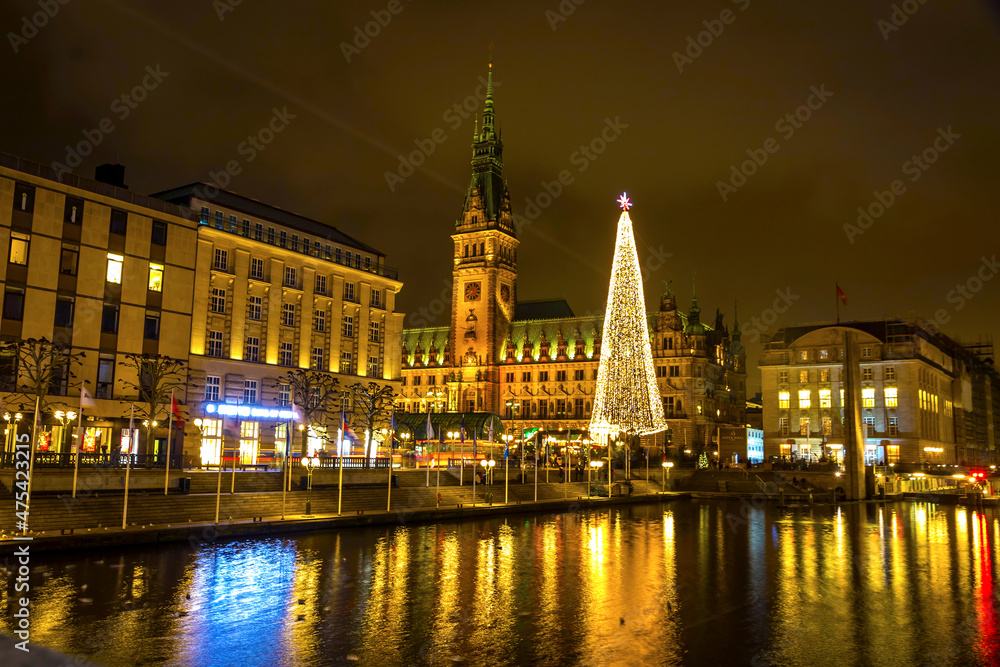 Night view of Binnenalster lake and Christmas market at Town Hall square near Hamburg Town Hall (Hamburg Rathaus), Germany. Christmas tree on the square