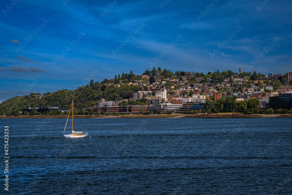 2021-12-16 THE ELLIOTT BAY SHOREINE NEAR LOWER QUEEN ANNE SEATTLEWITH A LONE SAILBOAT IN THE WATER