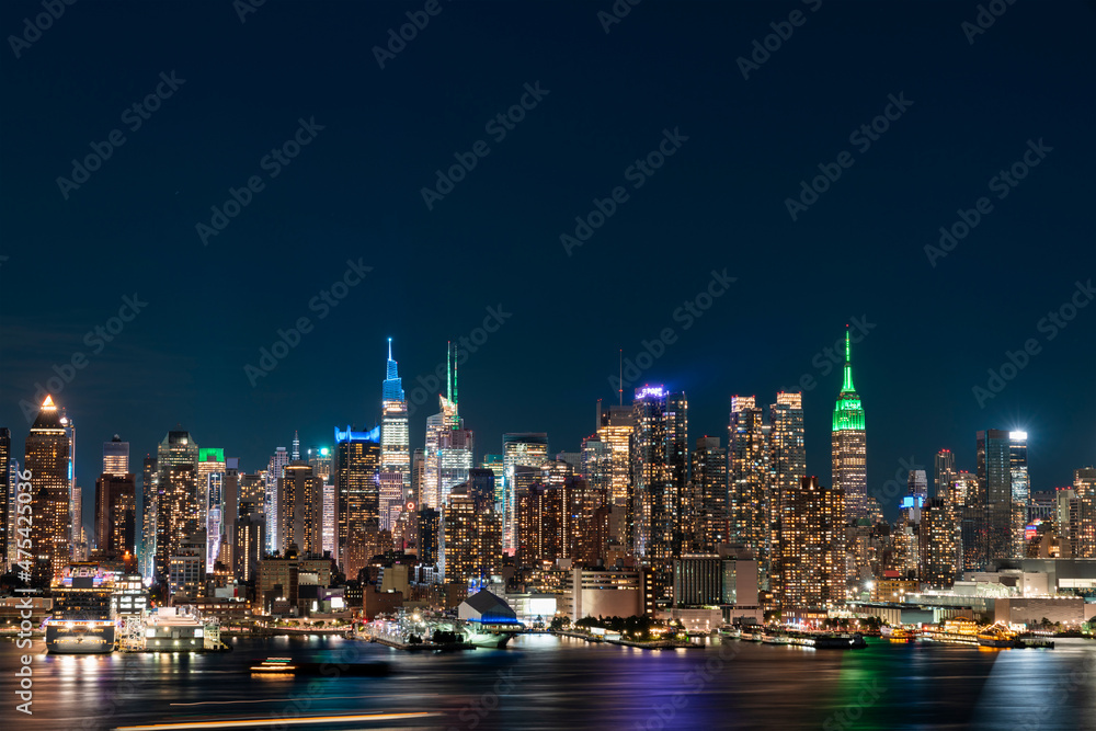 Aerial New York City skyline from New Jersey over the Hudson River with the skyscrapers of the Hudson Yards district at night. Manhattan, Midtown, NYC, USA. A vibrant business neighborhood