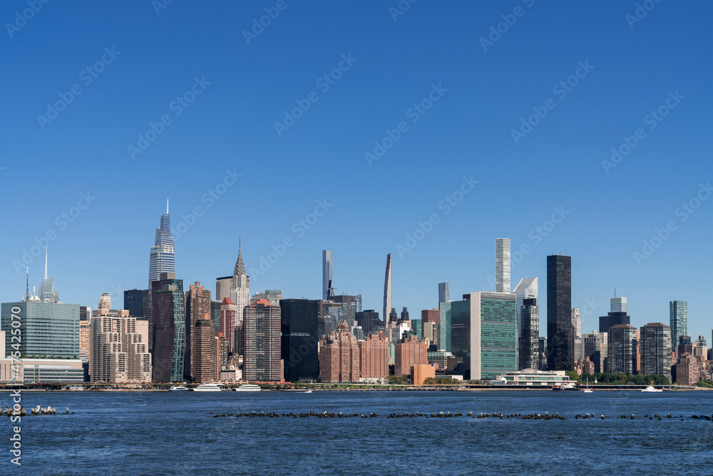New York City skyline from Brooklyn, Williamsburg over the East river towards the skyscrapers of Manhattan Midtown and United Nation headquarters at day time, NYC, USA. A vibrant business neighborhood