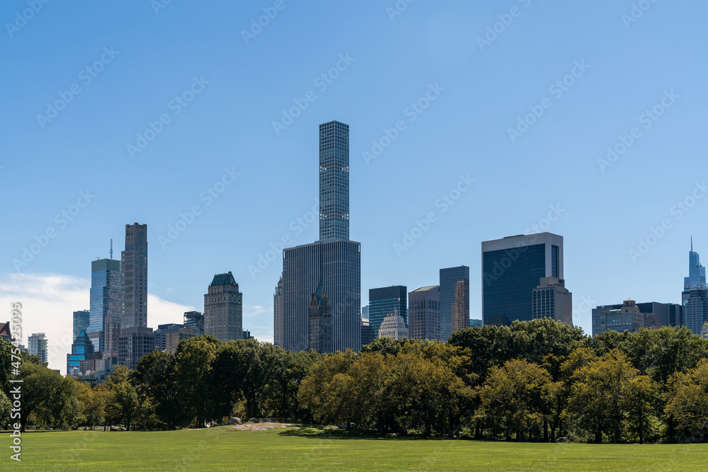 Green lawn at Central Park and Manhattan skyline skyscrapers at day time, New York City, USA Green lawn at Central Park and Manhattan skyline skyscrapers at day time, New York City, USA
