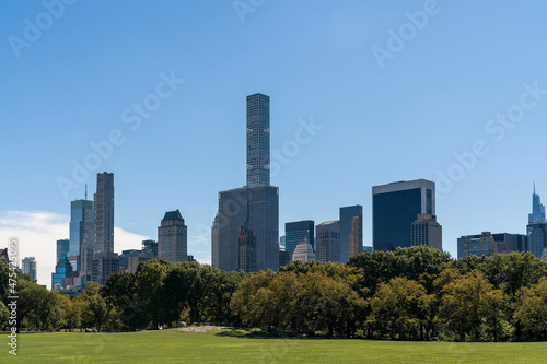 Green lawn at Central Park and Manhattan skyline skyscrapers at day time  New York City  USA