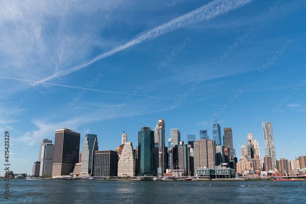Obraz premium Skyline of New York City Financial Downtown Skyscrapers over East River at day time, Manhattan, NYC, USA. A vibrant business neighborhood