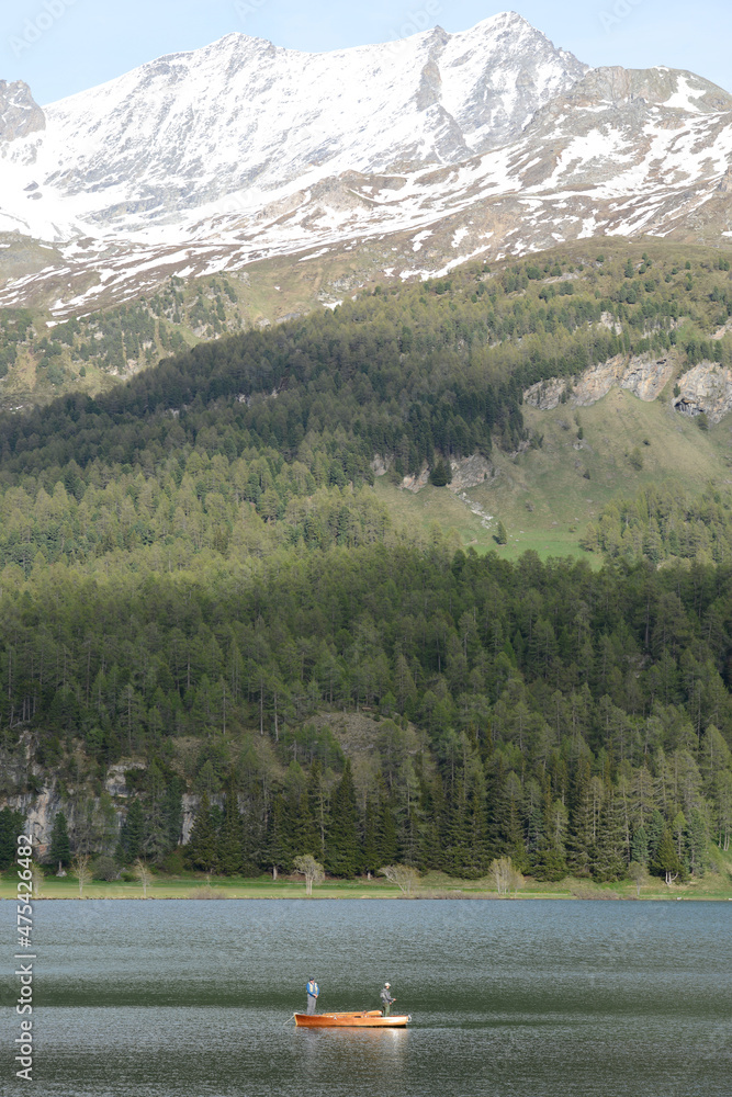 pêheur dans un barque sur un lac de montagne - Alpes Suisse