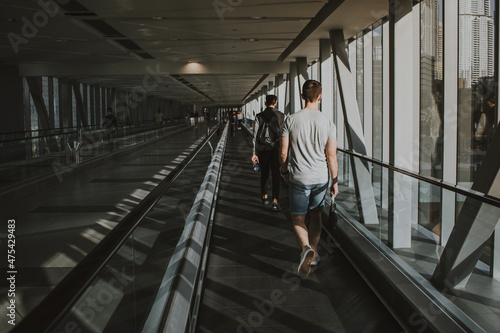 Young adult using respiratory protection with wearing cloth mask on face and walking on escalator indoor with social distancing