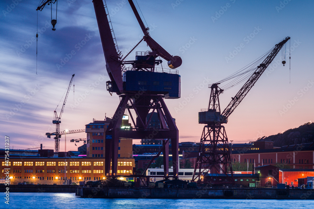 Sweden, Vastragotland and Bohuslan, Gothenburg, shipyard crane, city skyline, dusk