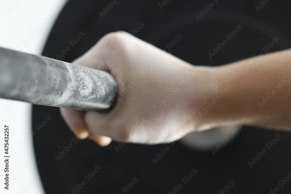 chalk hands holding onto a barbell for weightlifting or workout