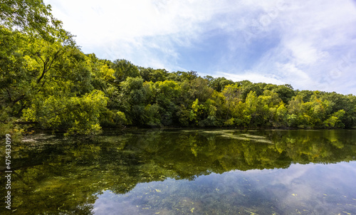 Canvas Print Beautiful view of the reflective clear lake Carver surrounded by dense green tre