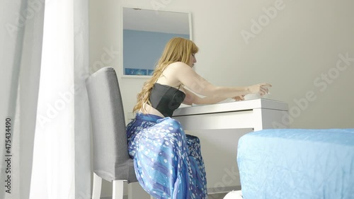 woman taking notes on a piece of paper - a student studying in her room photo