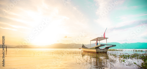 Beautiful sunset view of Timah Tasoh lake with boat by the lakeside. photo
