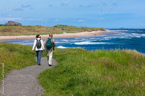 Tourists hiking along the coast of Northumberland, England, UK photo