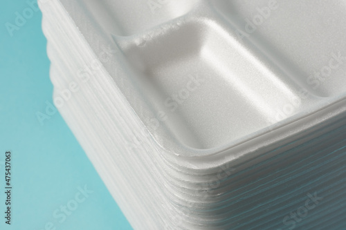 white Styrofoam plastic plates on blue background. Trash plastic, reusable plastic, disposable, for food. photo