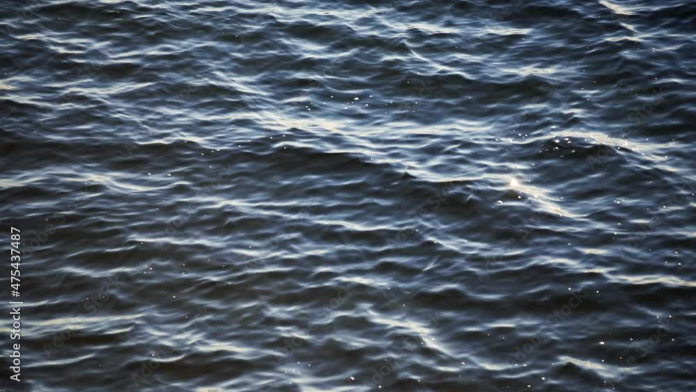 The waves of the lake sway in the wind. Small white air bubbles formed on the surface of the water. Alone with nature, relaxation. Close-up, 4K UHD. The waves of the lake sway in the wind. Small white air bubbles formed on the surface of the water. Alone with nature, relaxation. Close-up, 4K UHD.