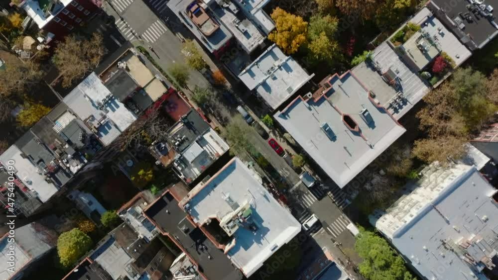 Aerial birds eye overhead top down panning view of rows of houses divided by streets and colourful autumn foliage of trees. Manhattan, New York City, USA Aerial birds eye overhead top down panning view of rows of houses divided by streets and colourful autumn foliage of trees. Manhattan, New York City, USA