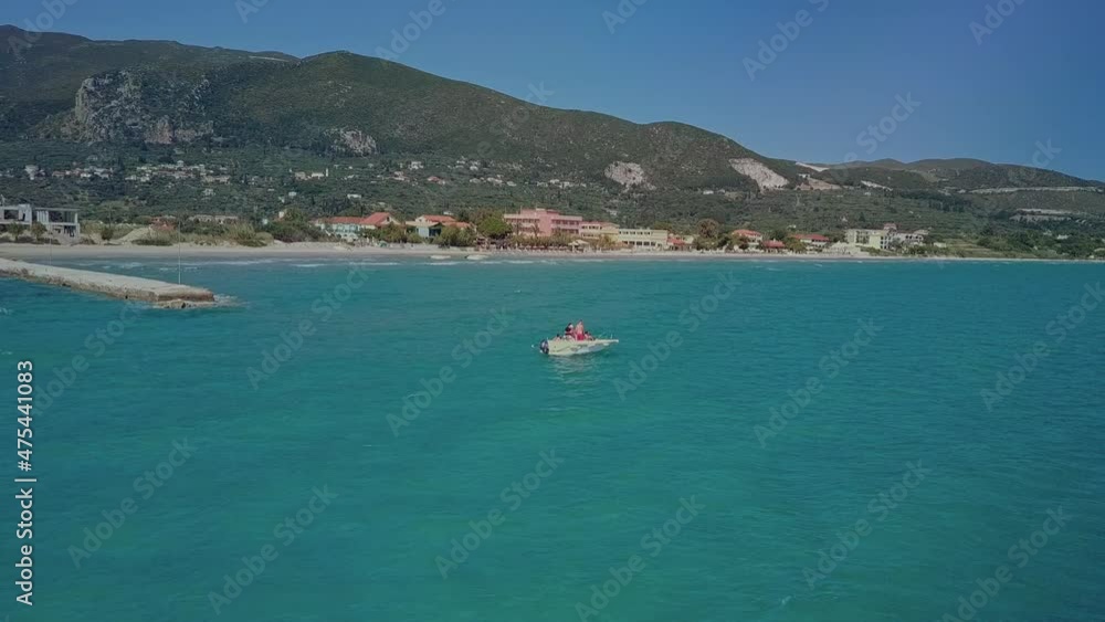Orbiting aerial around small boat in blue water near shore of Zakynthos Greece Orbiting aerial around small boat in blue water near shore of Zakynthos Greece
