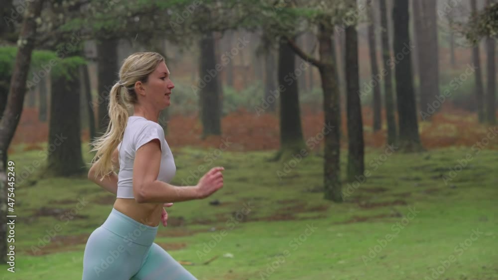 Fit attractive blond woman running through misty forest in slow motion Fit attractive blond woman running through misty forest in slow motion