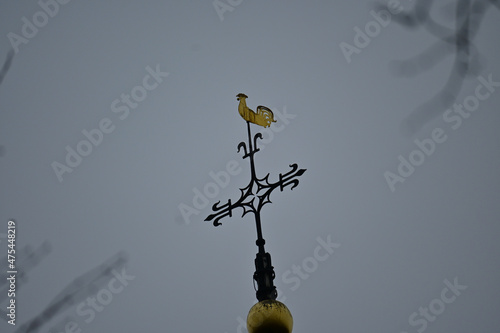 Antique cross on the top of a church on a gloomy day photo