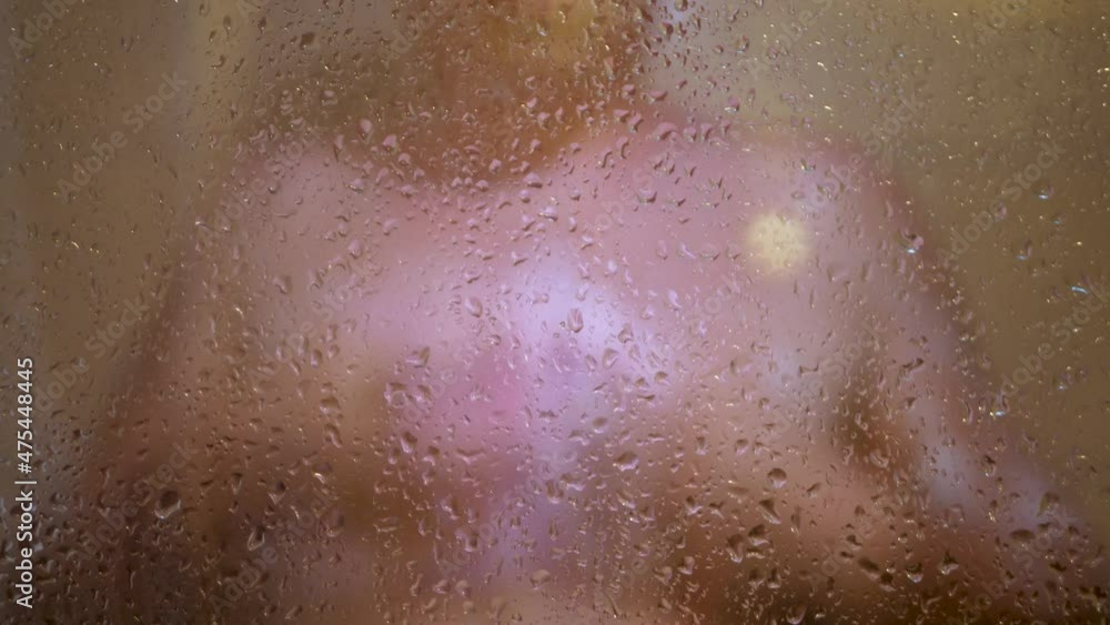 Unrecognizable naked man in shower washing body in bathroom. Male hold gel foam bath wisp. Enjoying everyday hygiene, clean skin care concept. Glass shower curtain with water drops Unrecognizable naked man in shower washing body in bathroom. Male hold gel foam bath wisp. Enjoying everyday hygiene, clean skin care concept. Glass shower curtain with water drops