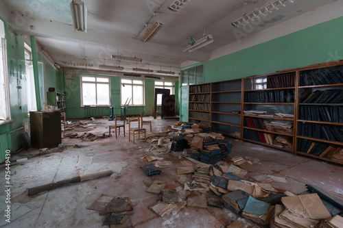 abandoned school classroom with tables and shelves