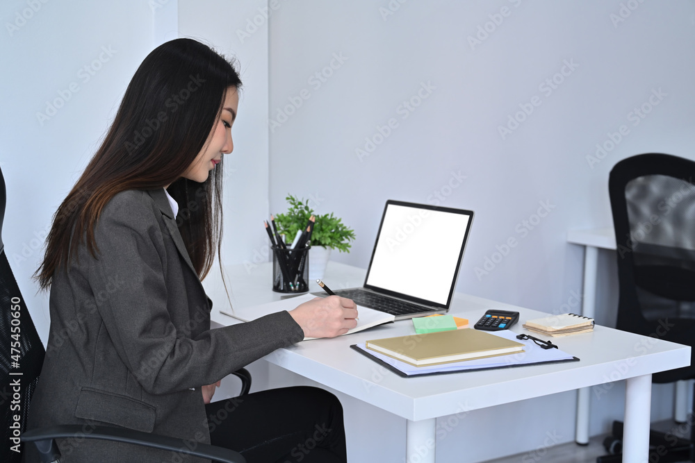 Side view asian businesswoman working with laptop in comfortable workplace. Side view asian businesswoman working with laptop in comfortable workplace.