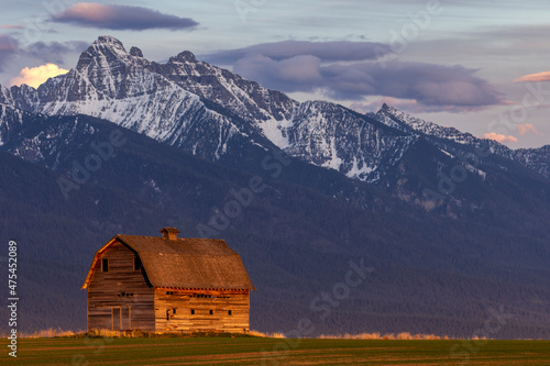 Rustic old barn in evening light with Mission Mountains in Pablo, Montana, USA photo
