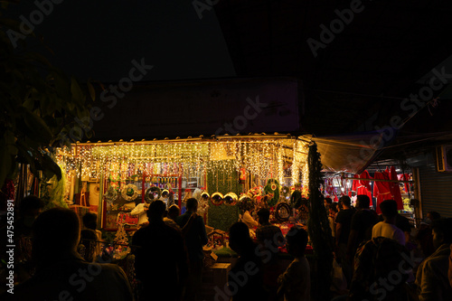 Ornamental Christmas lights Christmas market lightning paper lantern star hanging Kerala India lots of bright colorful stars night photo. Indian winter holidays shopping x-mas New Year celebration