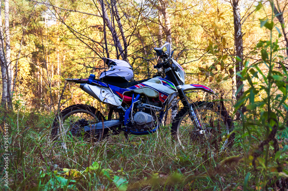 Cross-country motorcycle in a dense autumn forest