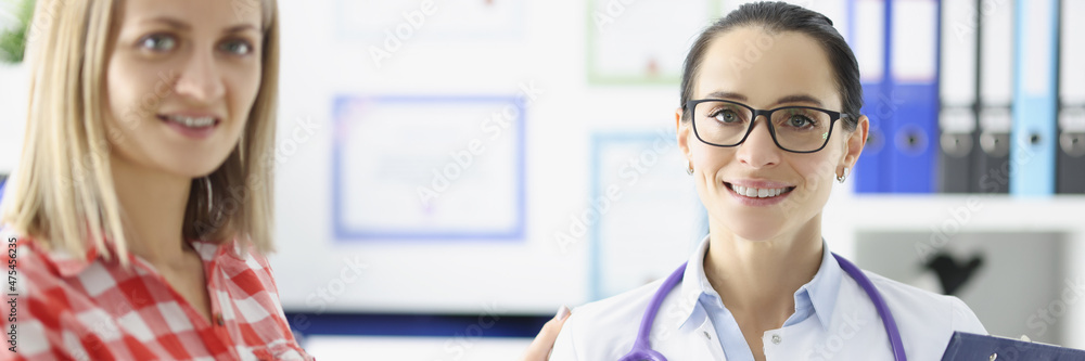 Female doctor hand shaking hand of patient and smiling Female doctor hand shaking hand of patient and smiling