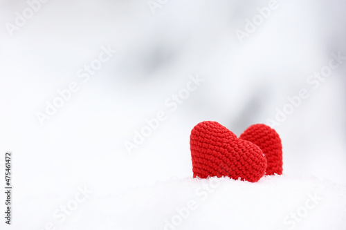Love hearts on the snow in winter park. Valentine s card  two knitted red symbols of love  background for romantic event  Christmas celebration