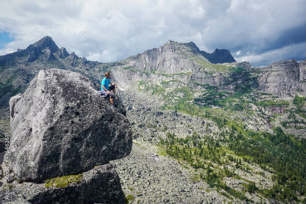 Hiker on top of a rock with a beautiful view of Ergaki natural practice