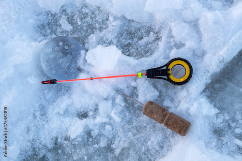 Winter fishing. Fish on ice. Fishing rods and equipment for winter fishing. Lake, snow and fishing. View from above.