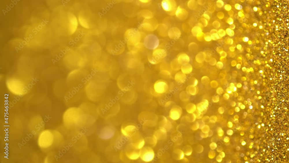 Gold Glitter Background. Light bokeh, magic christmas lights, shiny texture, holiday lights, flying particles form a beautiful bokeh. Shining festive Christmas backdrop. Vertical Video Gold Glitter Background. Light bokeh, magic christmas lights, shiny texture, holiday lights, flying particles form a beautiful bokeh. Shining festive Christmas backdrop. Vertical Video
